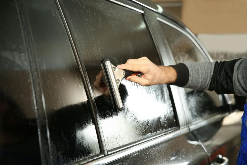 window tint applied to black car with squeegee